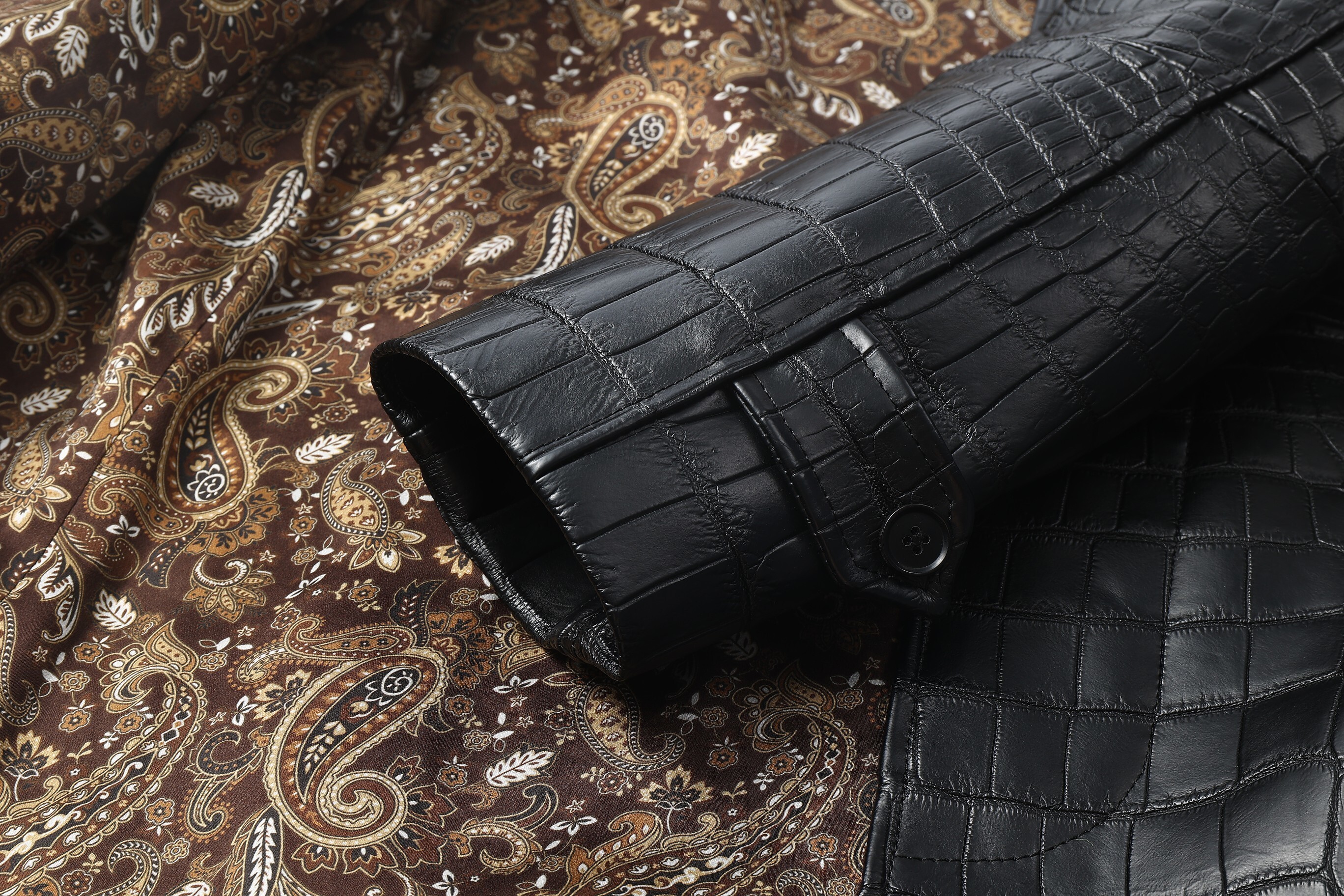 black crocodile-embossed leather coat or trench coat.