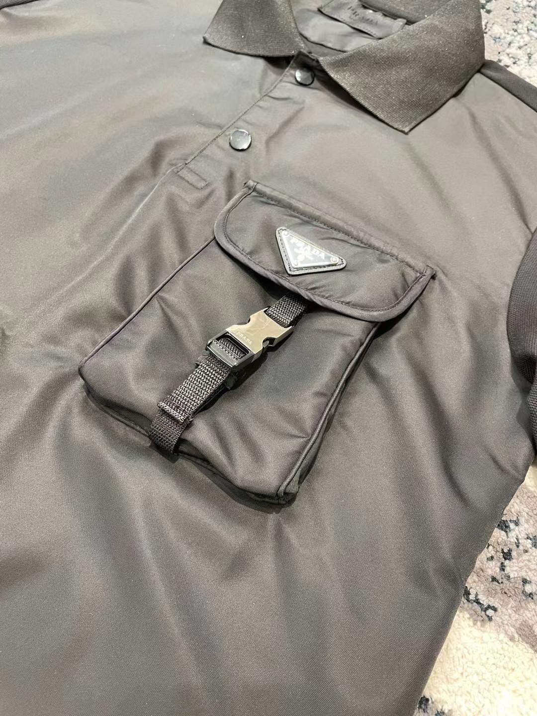 Prada men's stretch cotton polo shirt with a contrasting Re-Nylon breast pocket and the brand's iconic enameled metal triangle logo