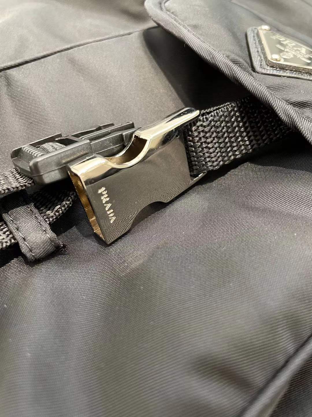 Prada men's stretch cotton polo shirt with a contrasting Re-Nylon breast pocket and the brand's iconic enameled metal triangle logo