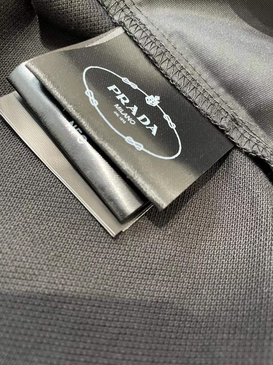 Prada men's stretch cotton polo shirt with a contrasting Re-Nylon breast pocket and the brand's iconic enameled metal triangle logo