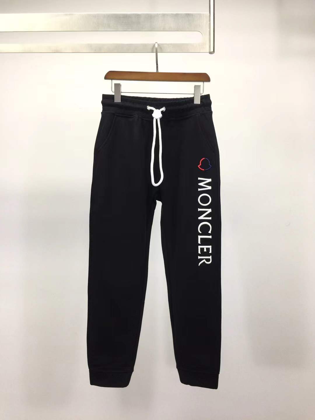 Moncler Black sweatpants with a white vertical logo print on the leg
