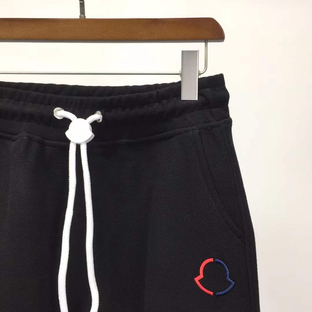 Moncler Black sweatpants with a white vertical logo print on the leg