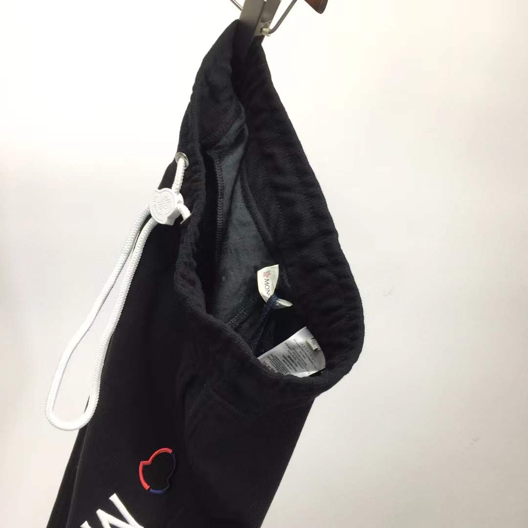 Moncler Black sweatpants with a white vertical logo print on the leg