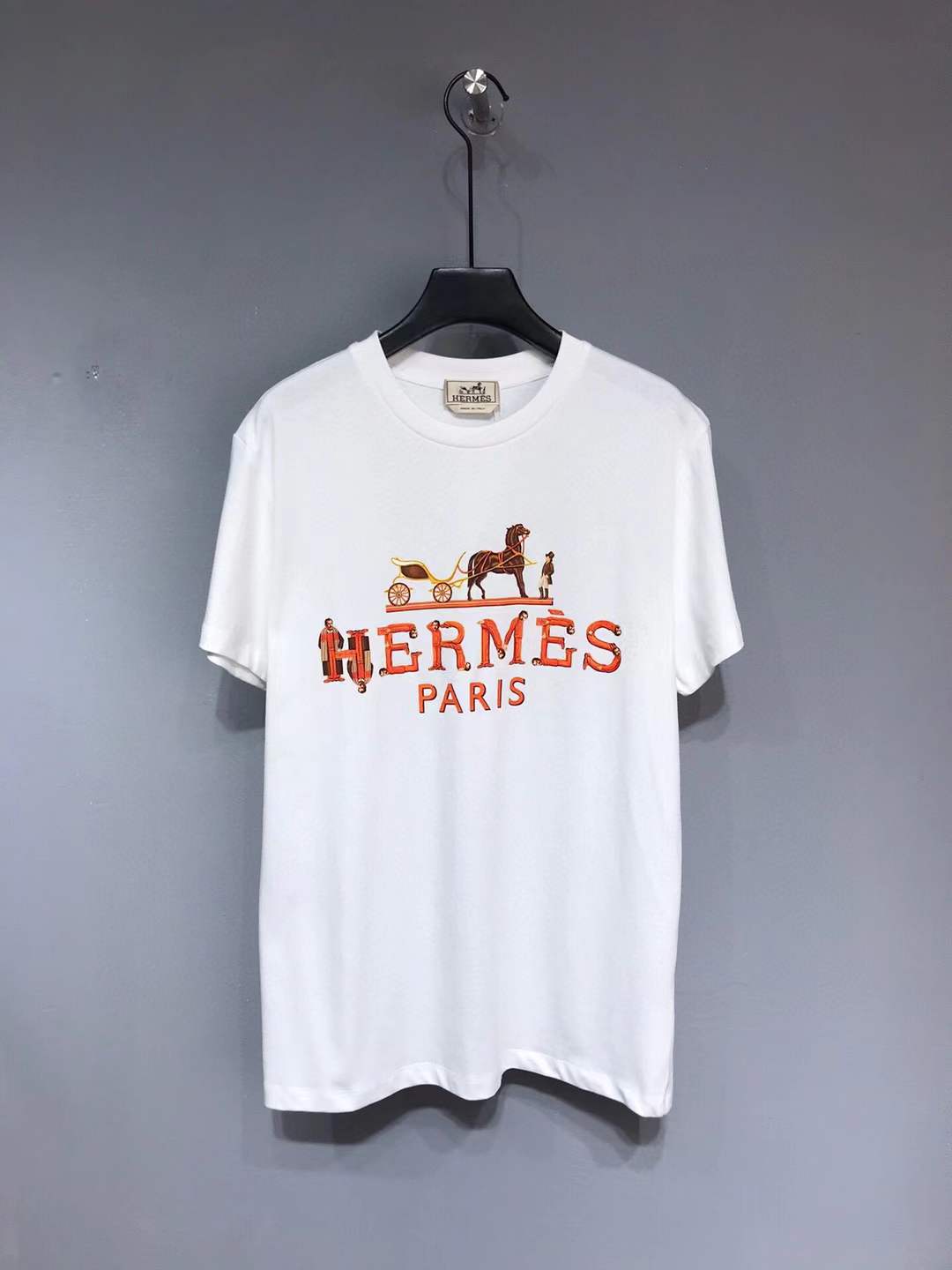Hermes Paris t-shirt with an orange and yellow logo graphic.