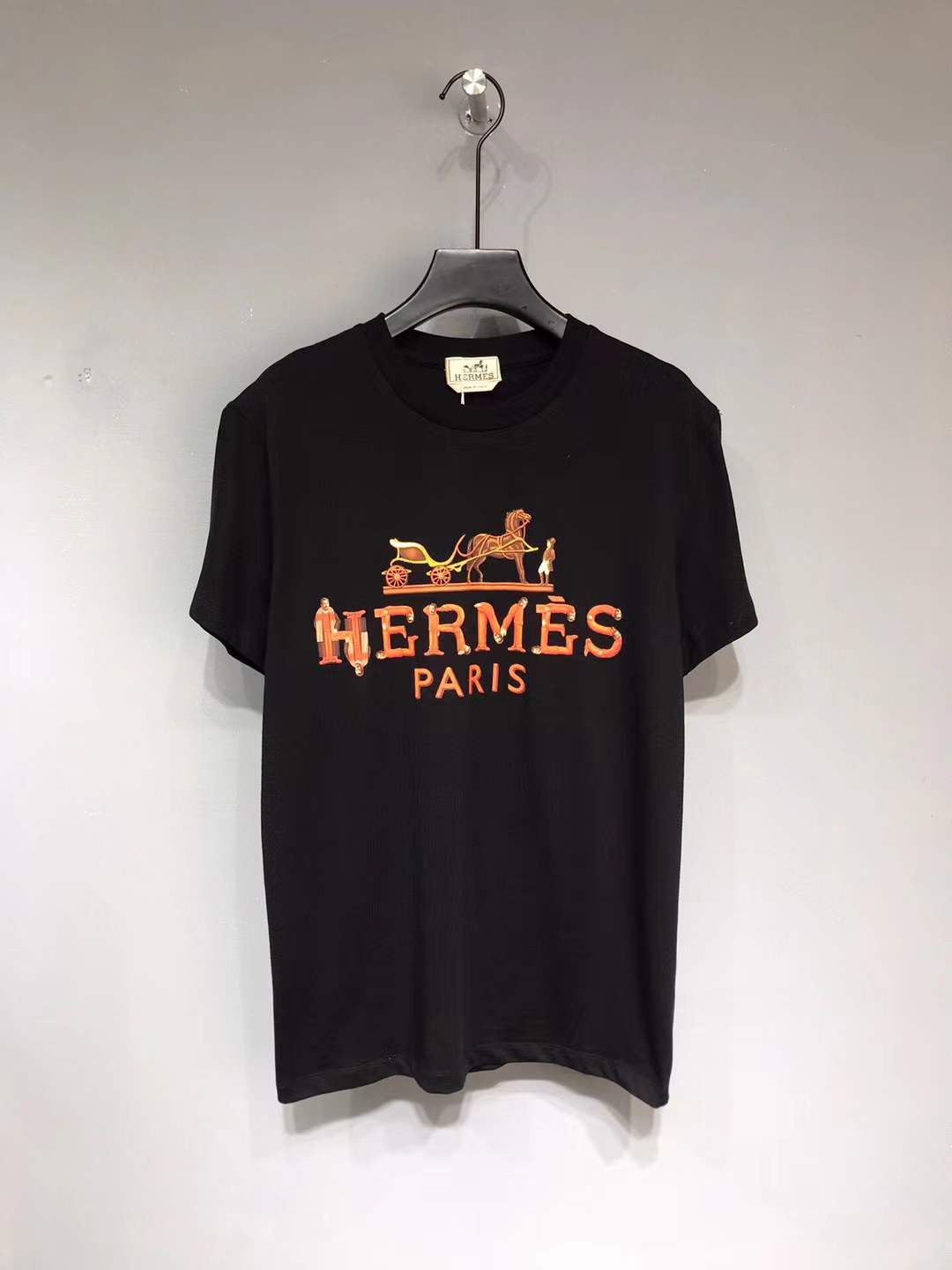 Hermes Paris t-shirt with an orange and yellow logo graphic.