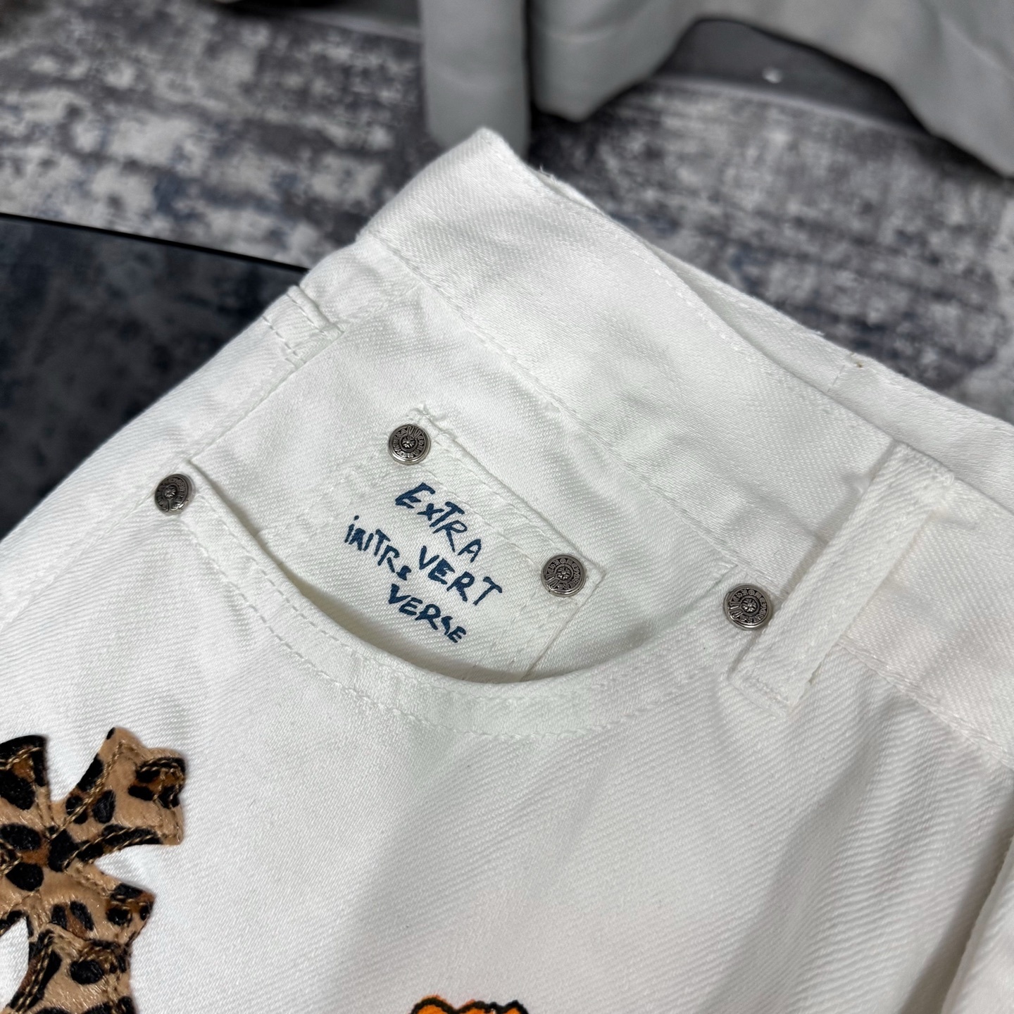 Chrome Hearts Matty Boy custom painted Levi's cross patch jeans in white denim with leopard print crosses.