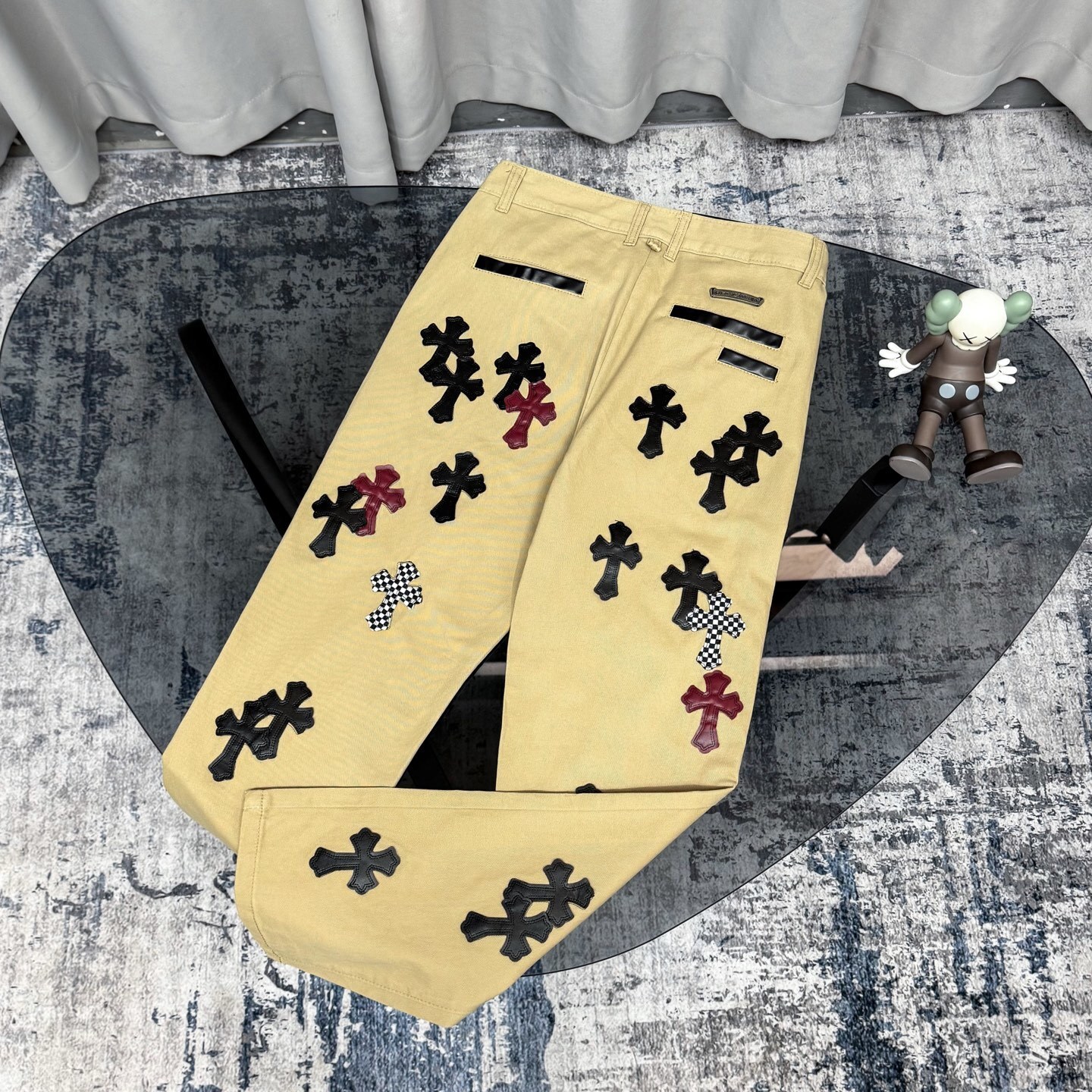 Chrome Hearts cross patch beige jeans.