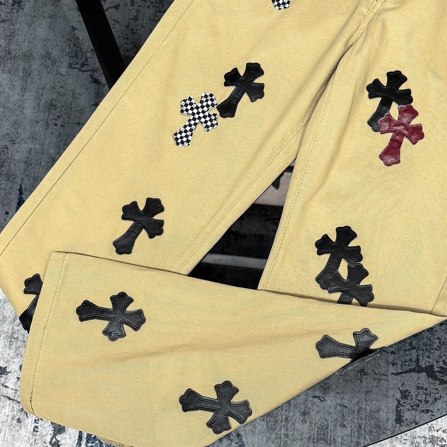 Chrome Hearts cross patch beige jeans.