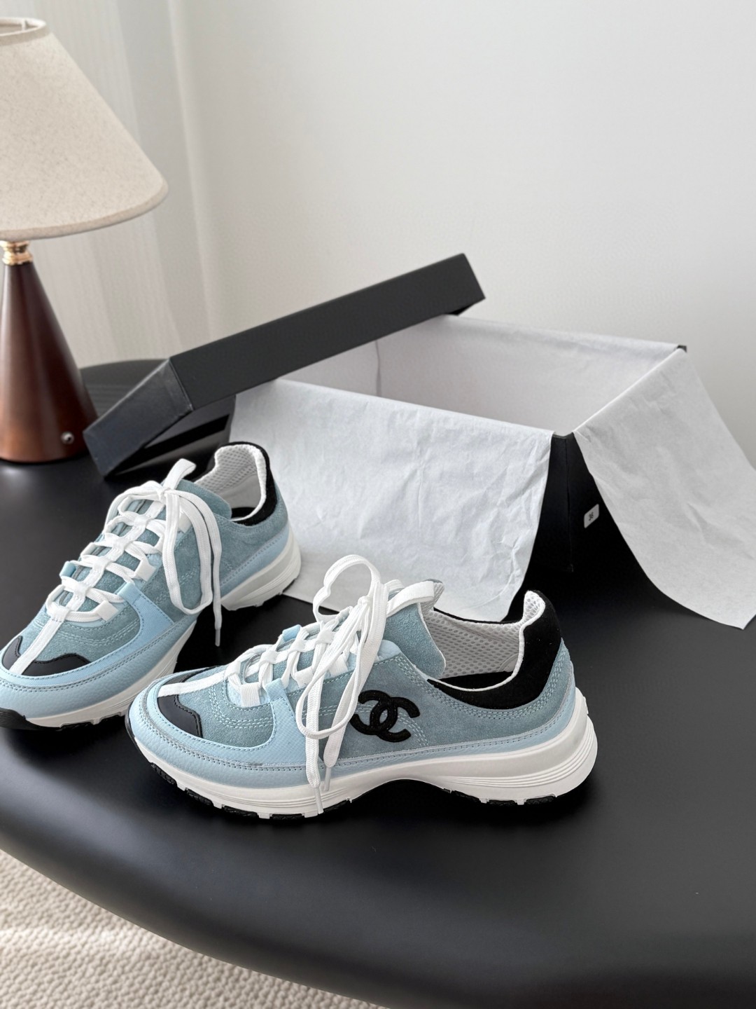 Chanel light blue and black Chanel suede calfskin grosgrain CC sneakers distinctive black CC logo on the side.