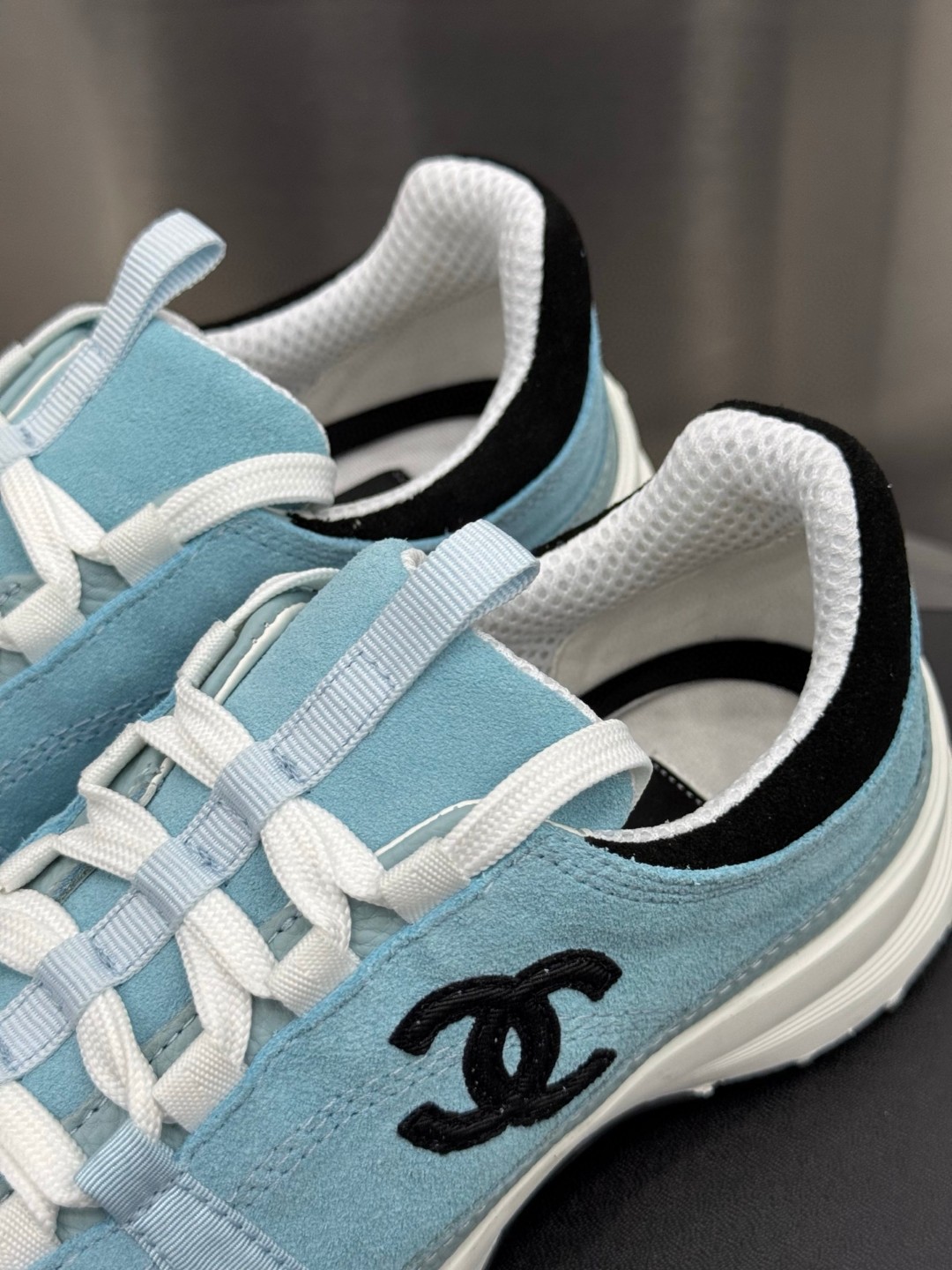 Chanel light blue and black Chanel suede calfskin grosgrain CC sneakers distinctive black CC logo on the side.