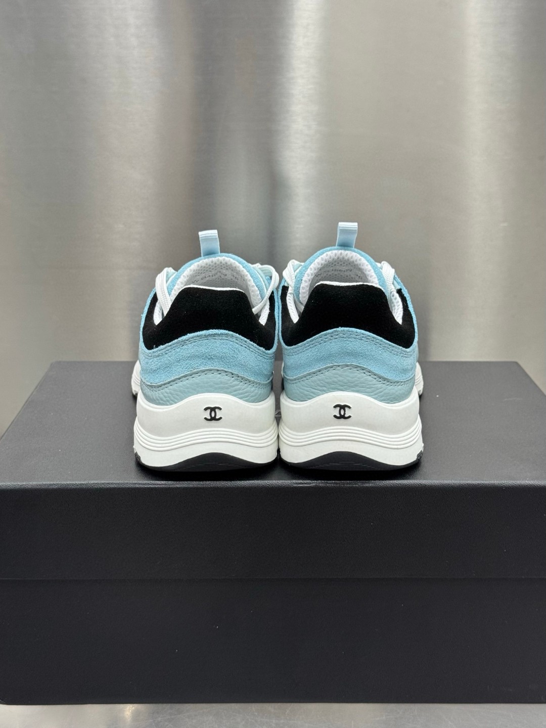 Chanel light blue and black Chanel suede calfskin grosgrain CC sneakers distinctive black CC logo on the side.