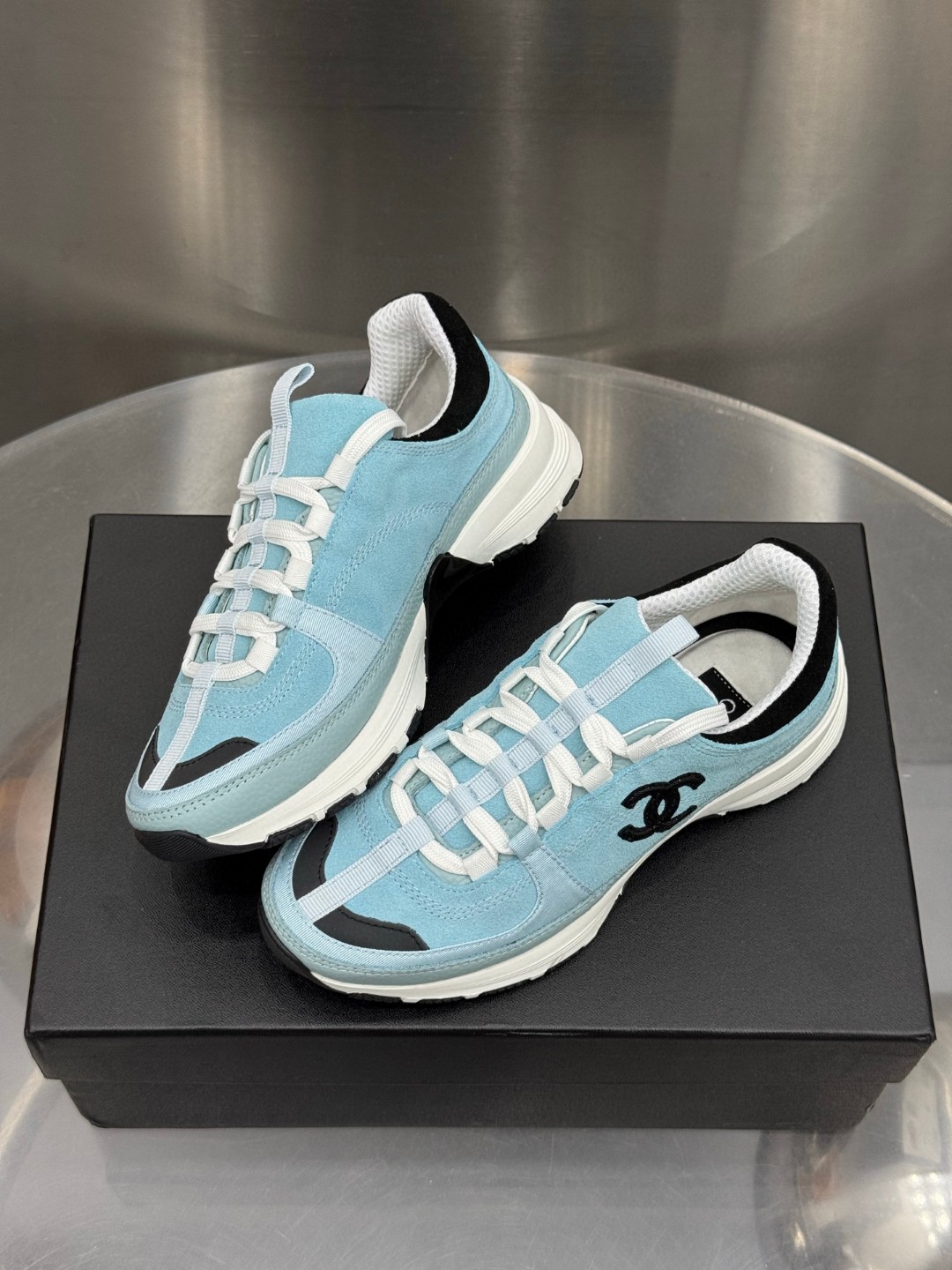 Chanel light blue and black Chanel suede calfskin grosgrain CC sneakers distinctive black CC logo on the side.