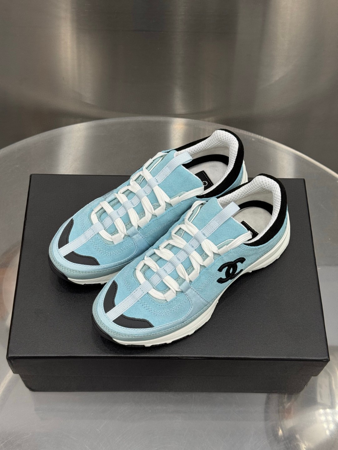 Chanel light blue and black Chanel suede calfskin grosgrain CC sneakers distinctive black CC logo on the side.