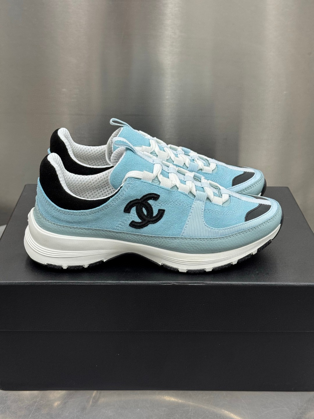 Chanel light blue and black Chanel suede calfskin grosgrain CC sneakers distinctive black CC logo on the side.