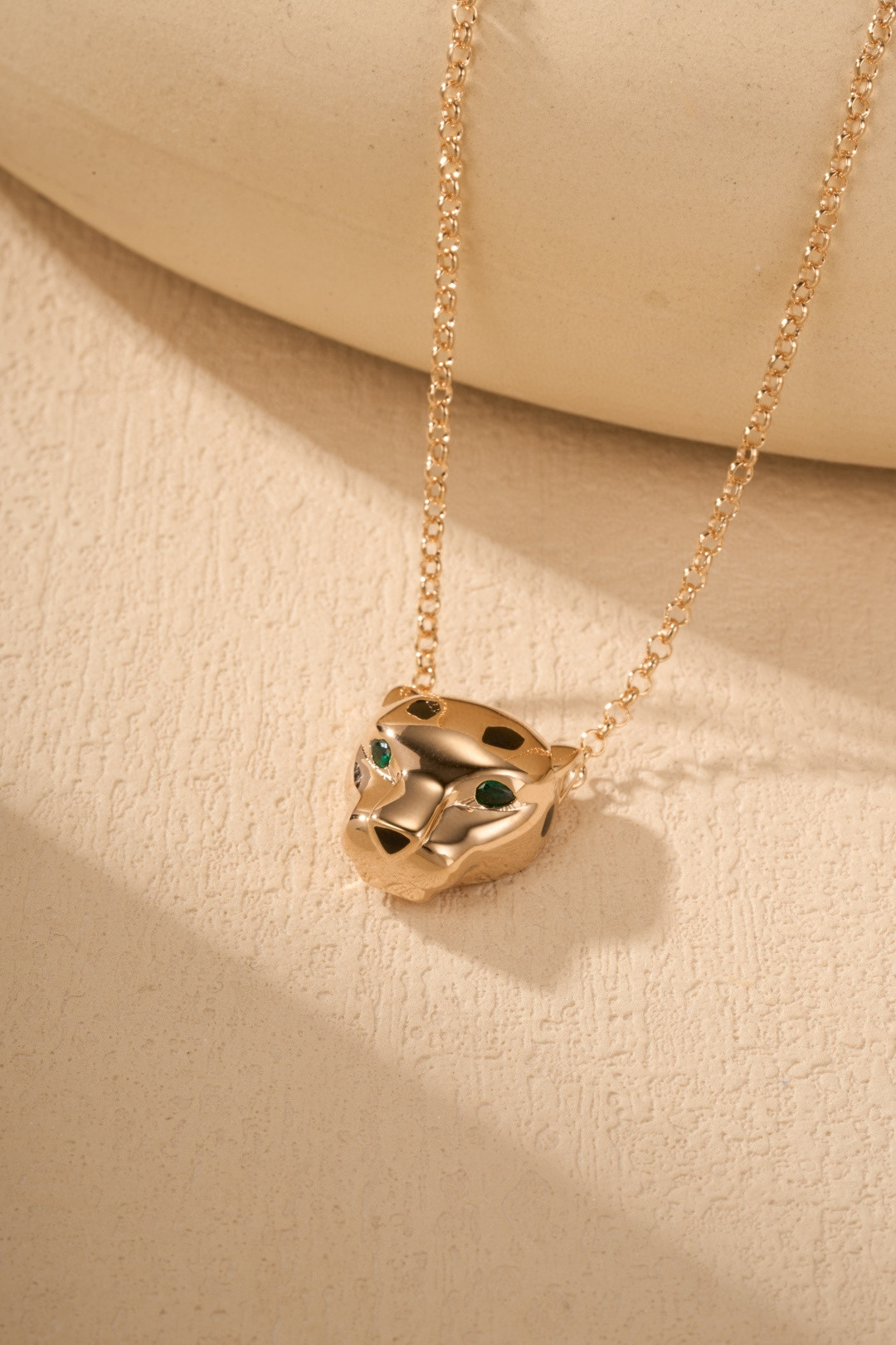 Cartier Panthère-style pendant necklaces featuring a silver-tone and gold-tone finish with green gemstone eyes.