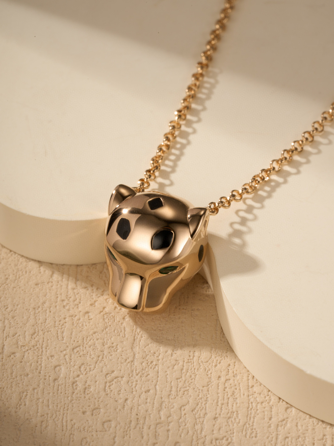 Cartier Panthère-style pendant necklaces featuring a silver-tone and gold-tone finish with green gemstone eyes.