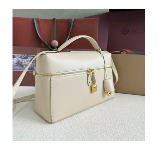 Loro Piana Extra Bag likely the L27 size in a light leather color, featuring a structural shape with double zippers and iconic charms