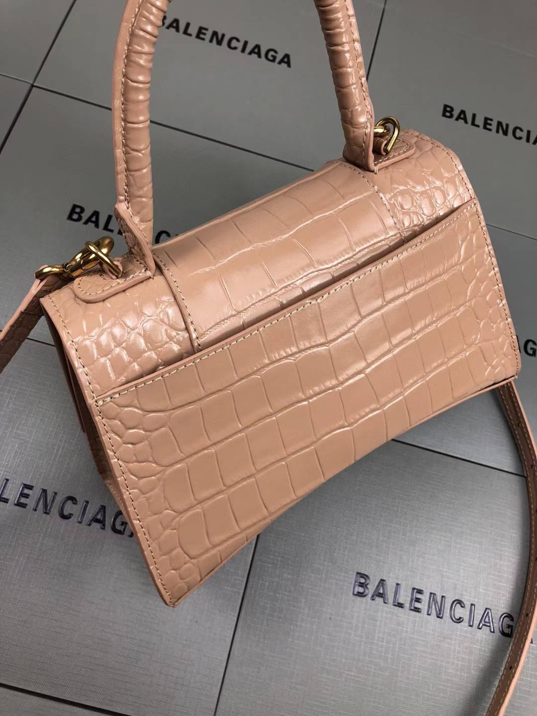 Balenciaga Hourglass handbag likely the Small or XS model, crafted from beige crocodile-embossed leather and featuring the signature B logo plaque