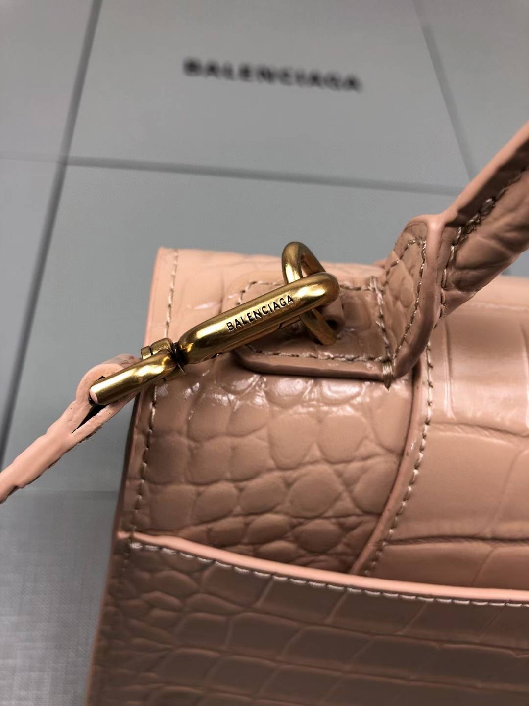 Balenciaga Hourglass handbag likely the Small or XS model, crafted from beige crocodile-embossed leather and featuring the signature B logo plaque