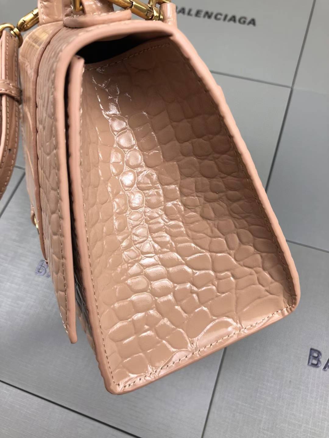 Balenciaga Hourglass handbag likely the Small or XS model, crafted from beige crocodile-embossed leather and featuring the signature B logo plaque
