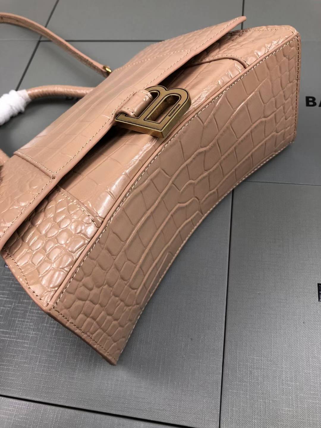 Balenciaga Hourglass handbag likely the Small or XS model, crafted from beige crocodile-embossed leather and featuring the signature B logo plaque