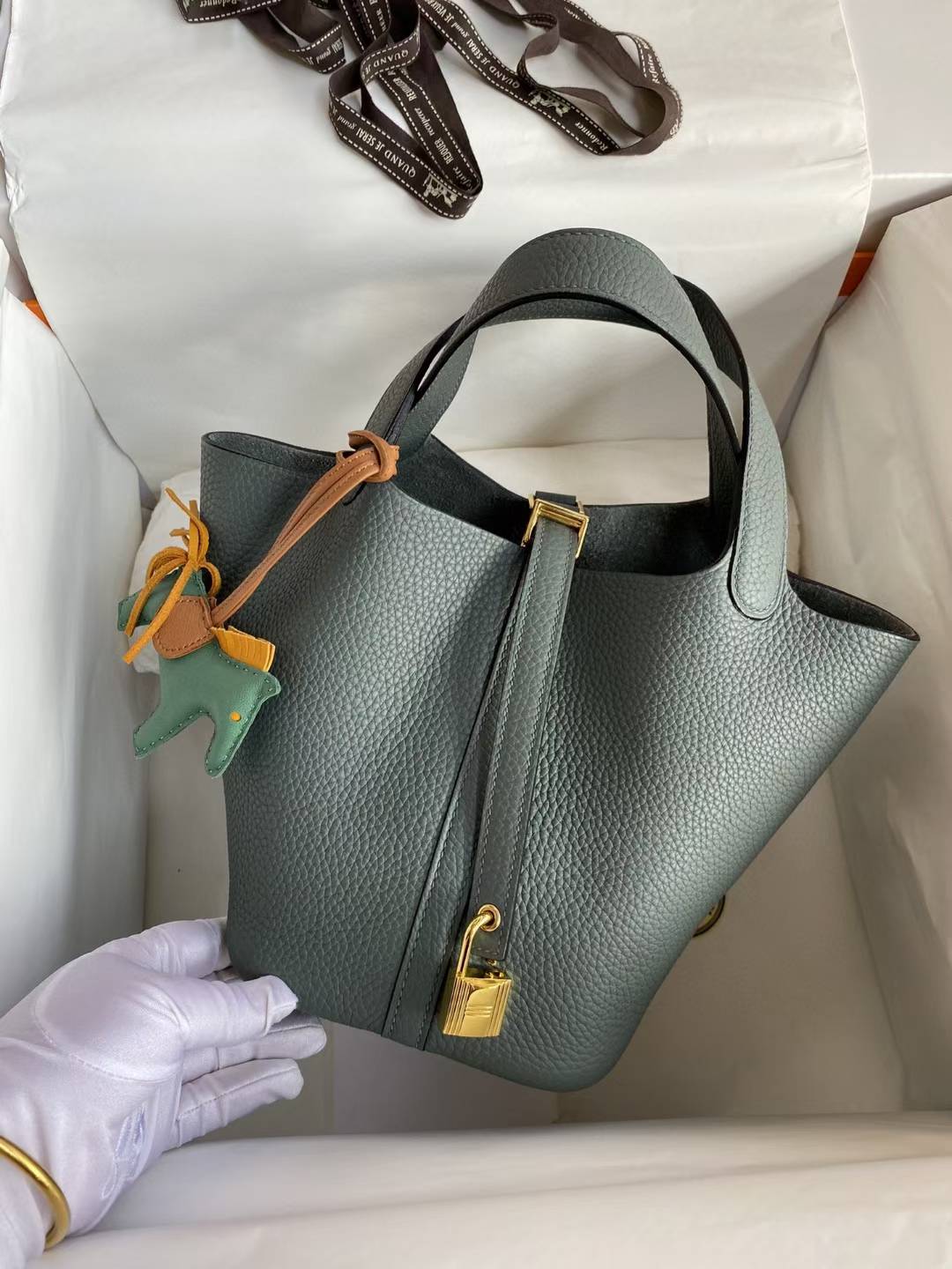 Hermès Picotin Lock 18 bag in a green shade, likely Vert Mangrove or Gris Meyer, featuring Clemence leather and gold hardware