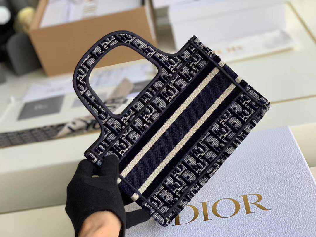 Christian Dior Mini Book Tote in Blue Dior Oblique Embroidery, which features the signature logo on the front