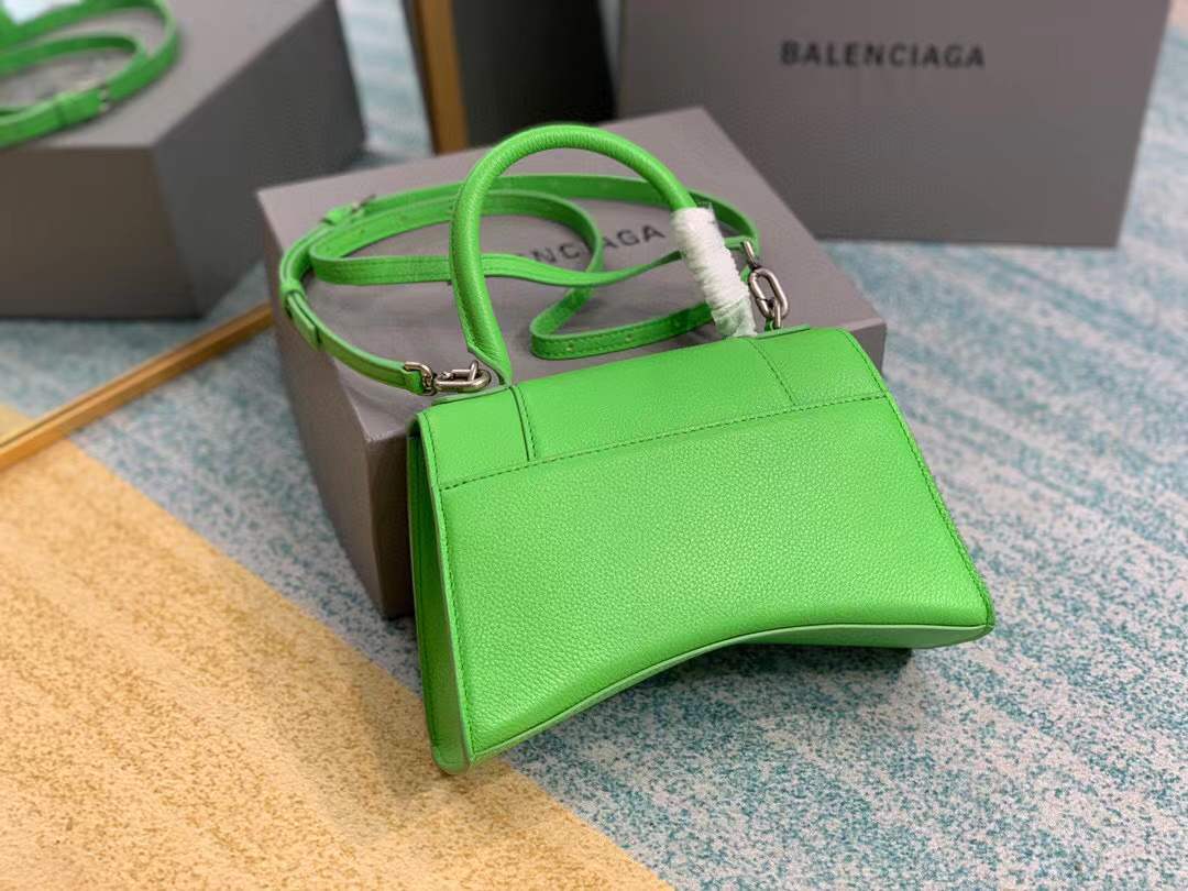 Balenciaga Hourglass bag, a structured leather handbag featuring a curved base and a signature "B" logo closure.