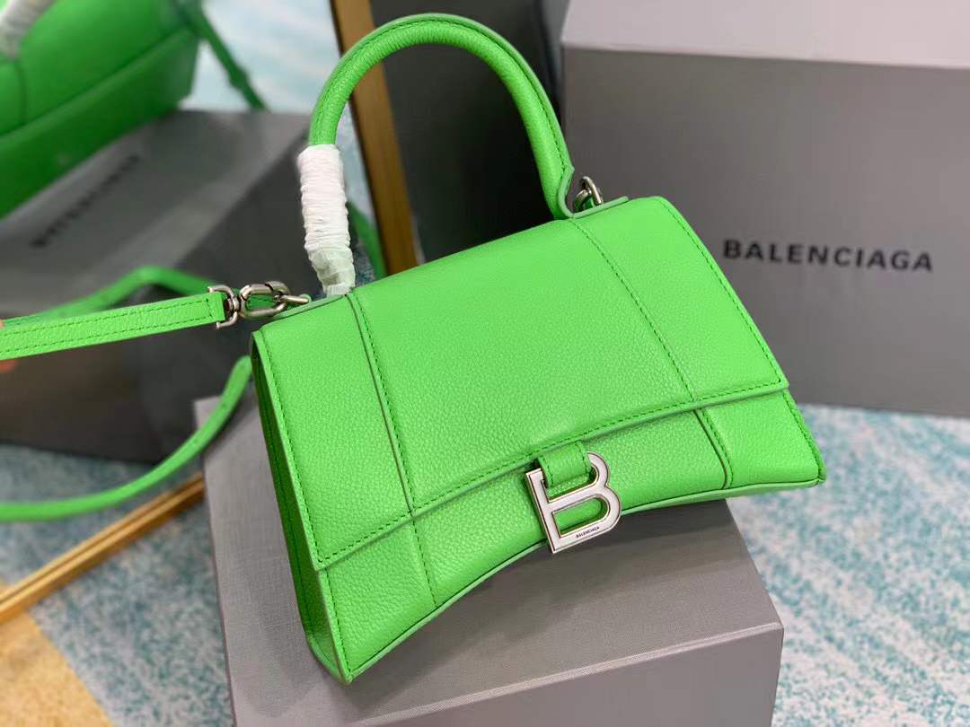 Balenciaga Hourglass bag, a structured leather handbag featuring a curved base and a signature "B" logo closure.