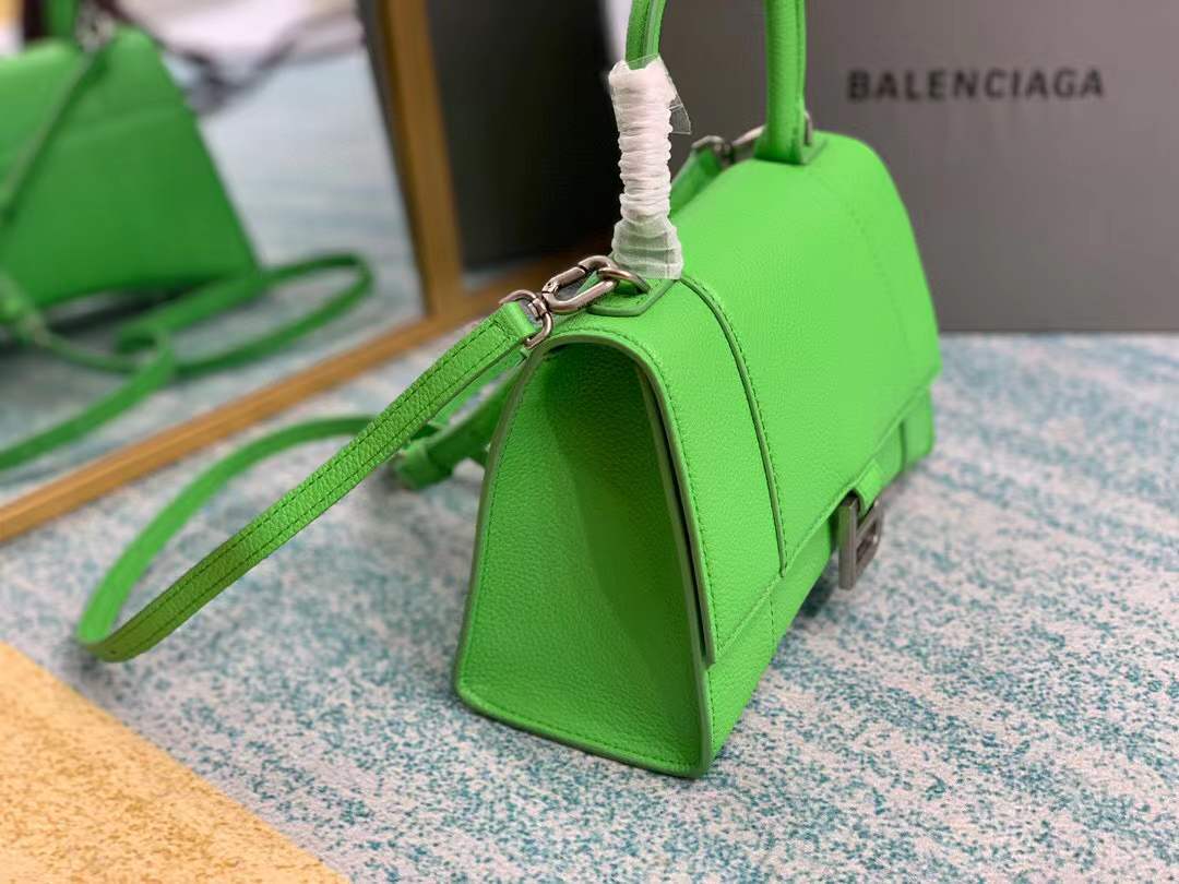 Balenciaga Hourglass bag, a structured leather handbag featuring a curved base and a signature "B" logo closure.