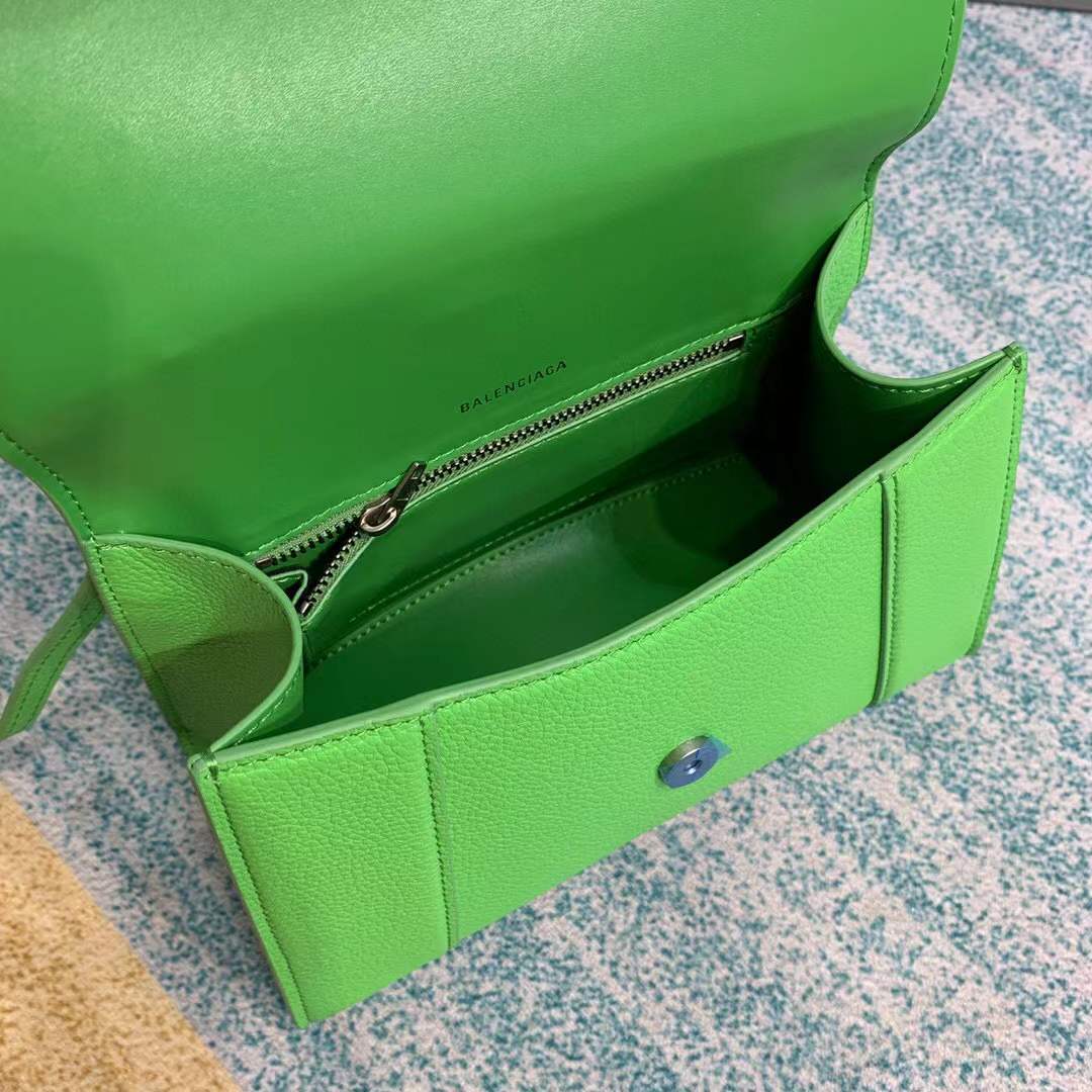 Balenciaga Hourglass bag, a structured leather handbag featuring a curved base and a signature "B" logo closure.