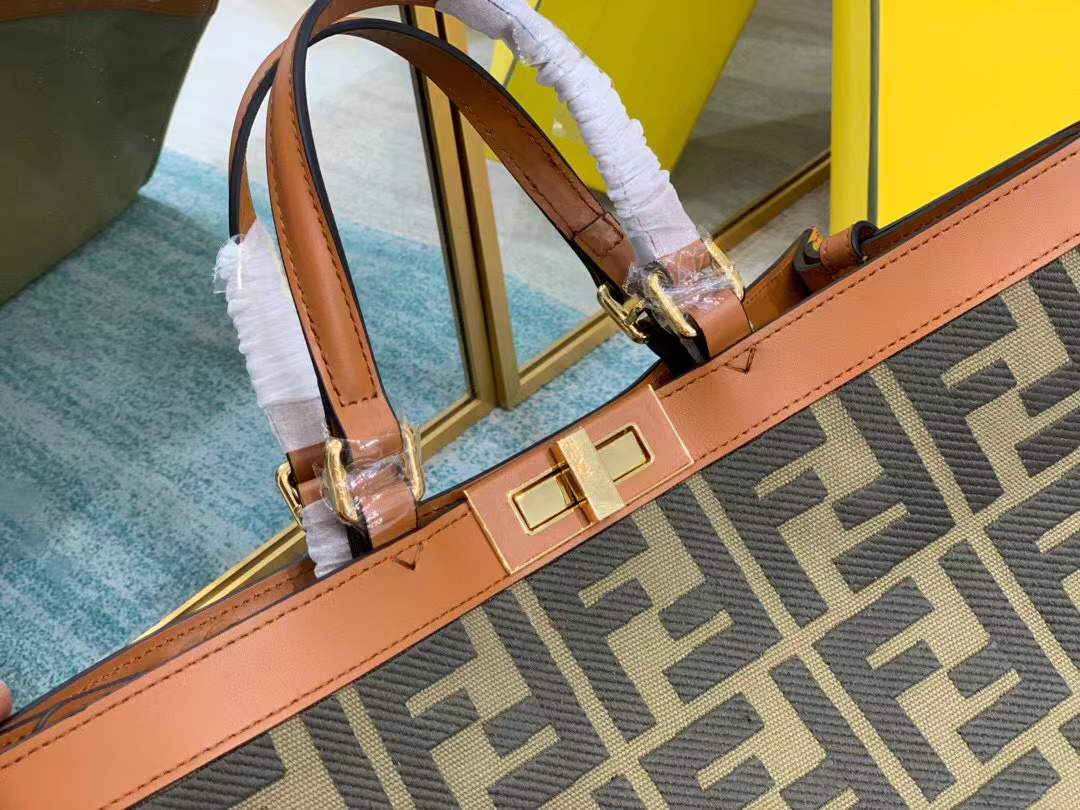 Fendi Peekaboo X-Tote bag features the iconic FF monogram pattern on canvas, brown leather trim, and gold-tone hardware