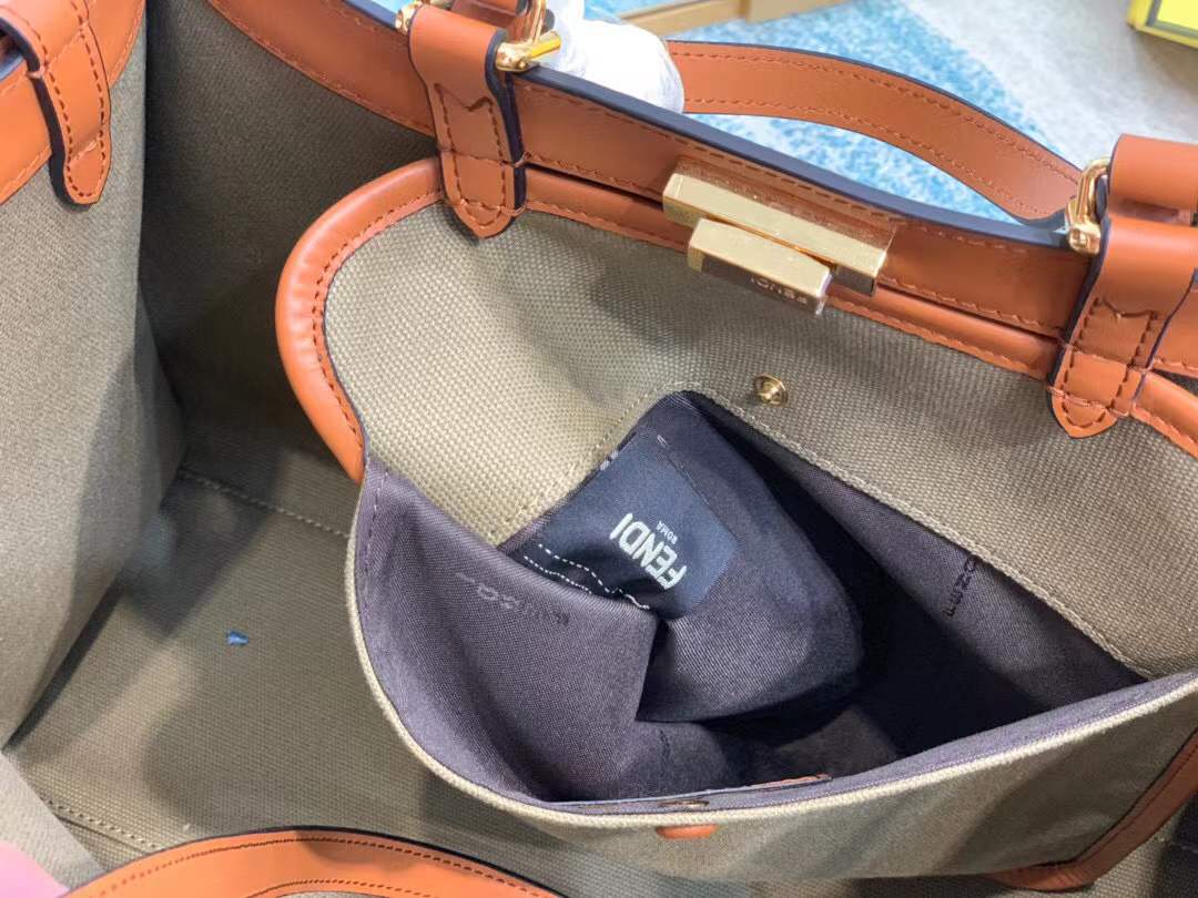 Fendi Peekaboo X-Tote bag features the iconic FF monogram pattern on canvas, brown leather trim, and gold-tone hardware