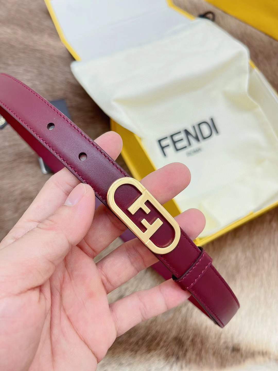 Fendi FF logo belt in red, featuring a gold-toned monogram buckle
