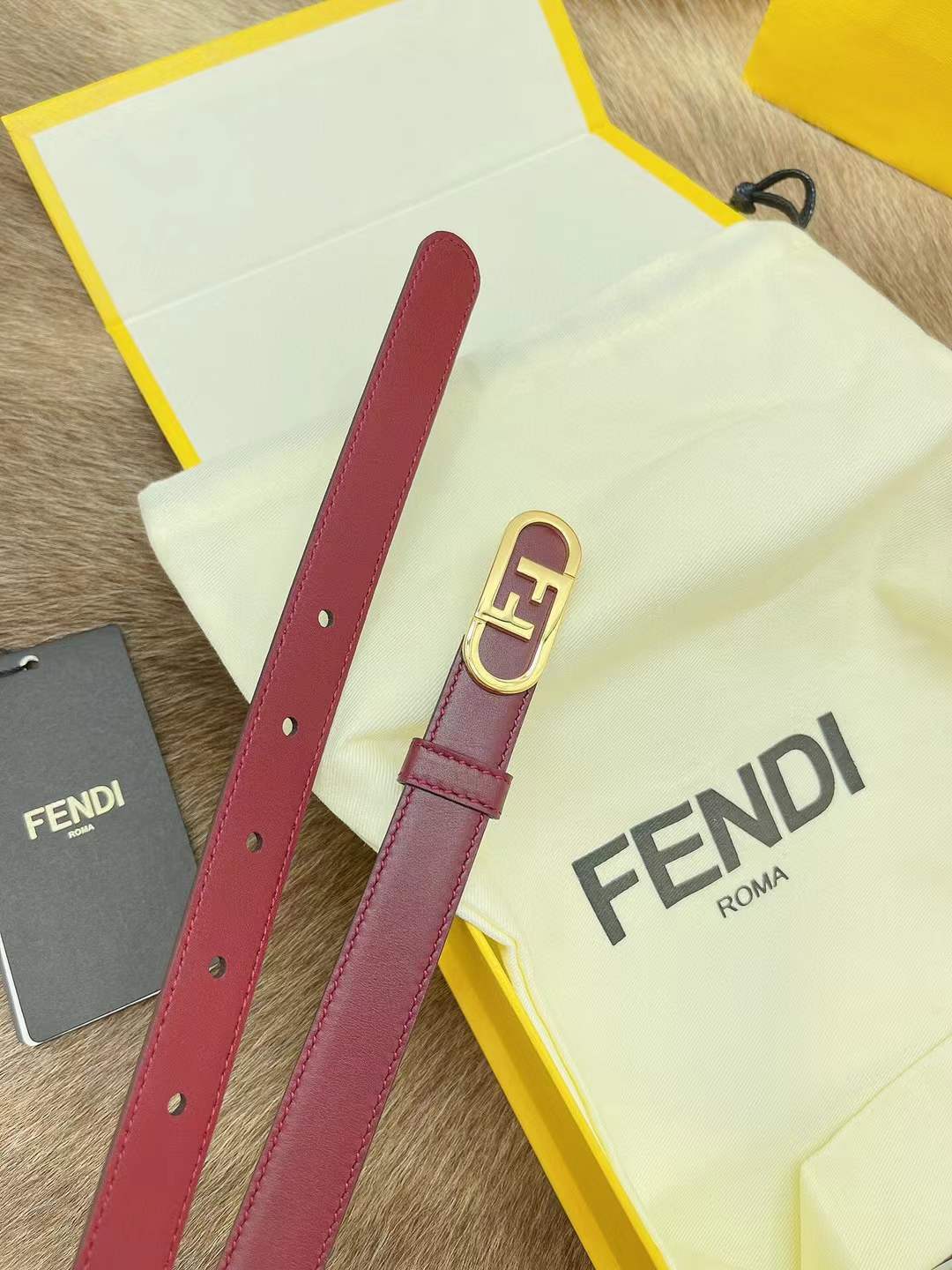 Fendi FF logo belt in red, featuring a gold-toned monogram buckle