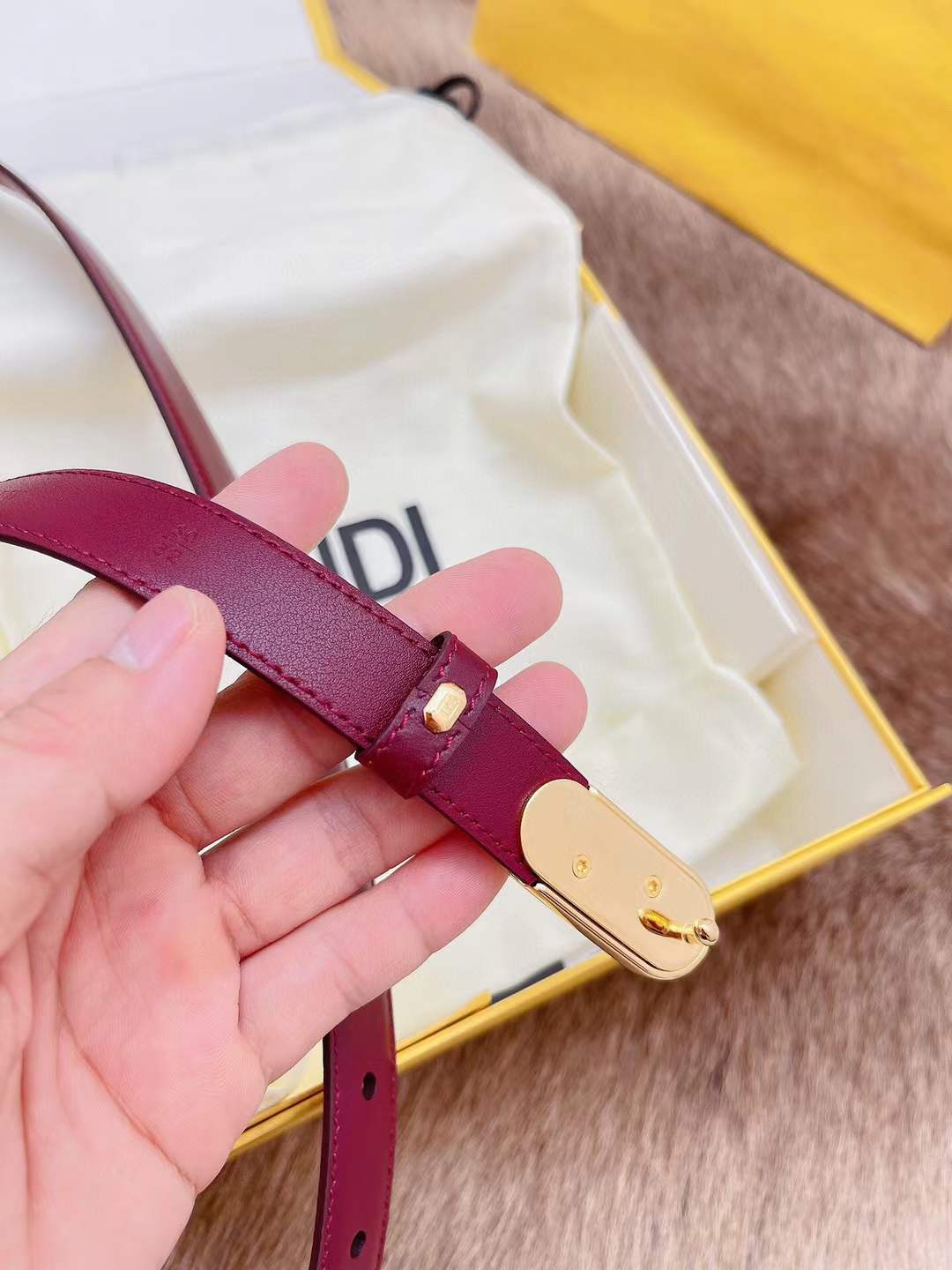 Fendi FF logo belt in red, featuring a gold-toned monogram buckle