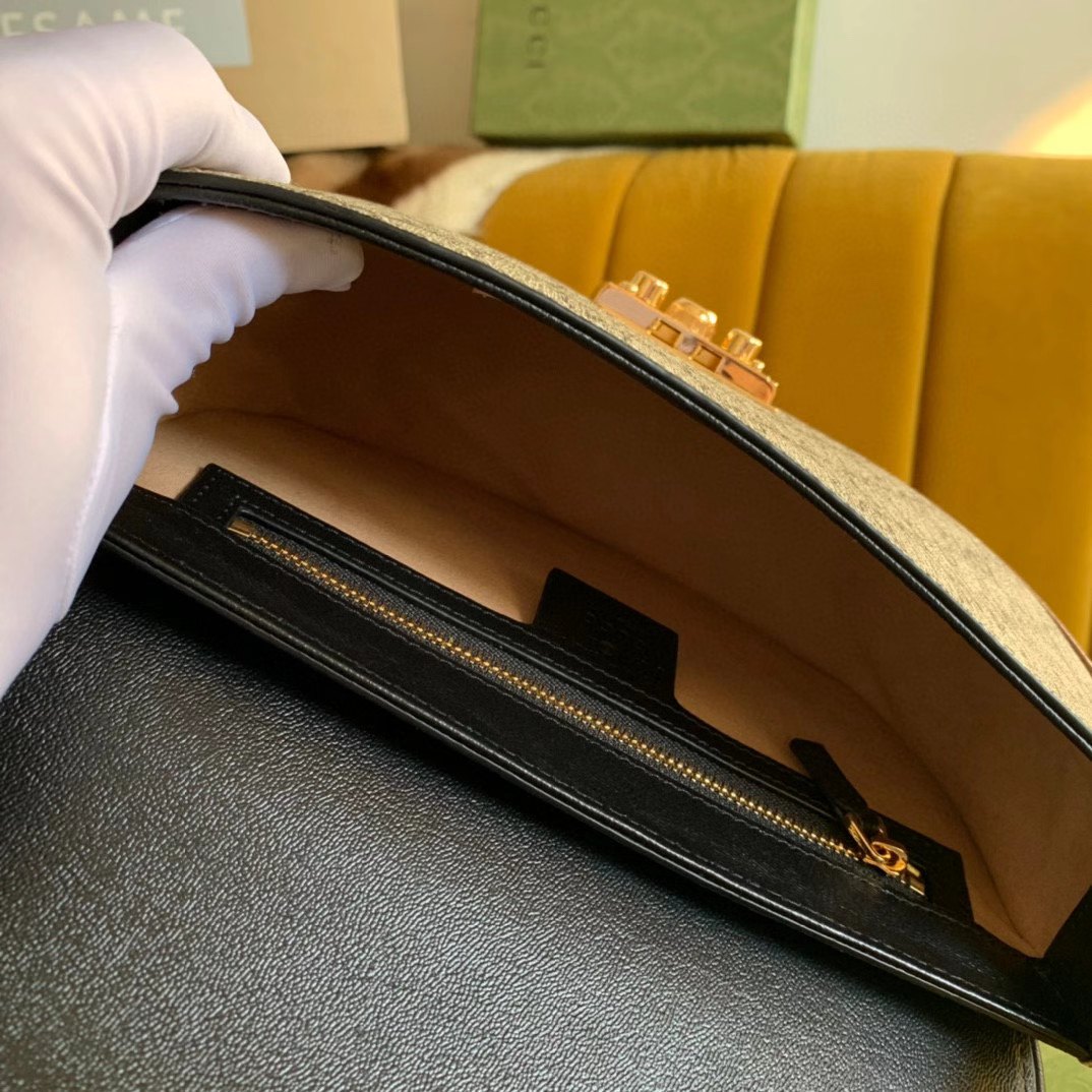 Gucci Padlock Saddle Shoulder Bag features GG Supreme canvas with black leather trim and a gold-toned padlock closure