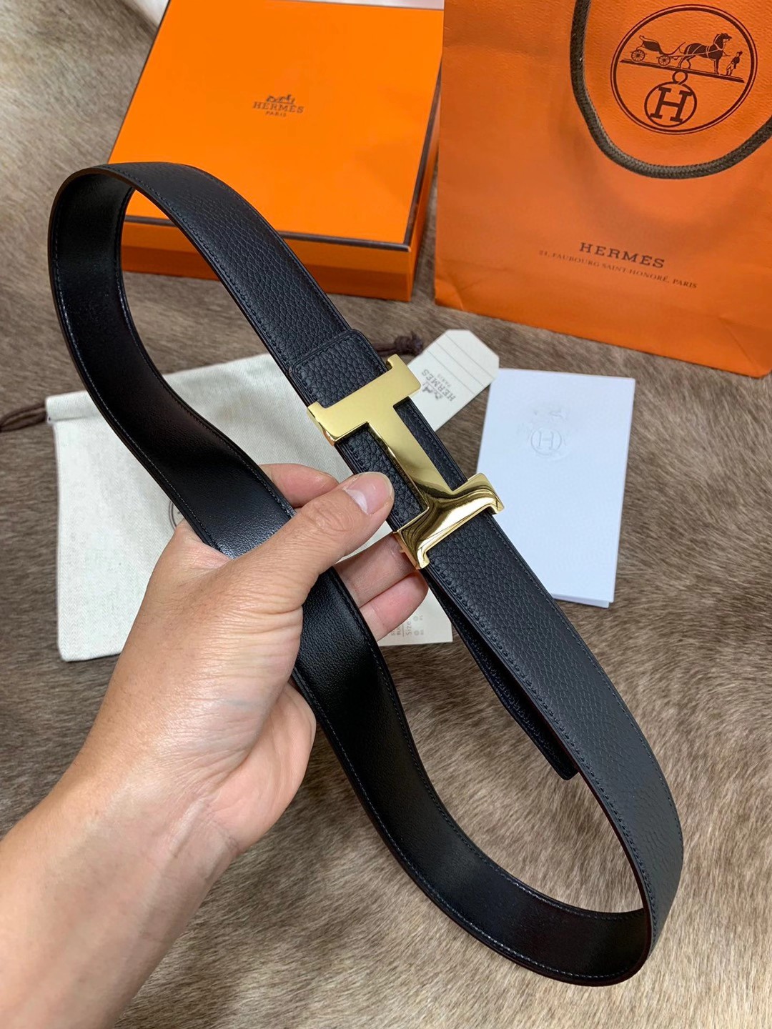 Hermès men's black leather belt featuring the brand's iconic "H" logo buckle