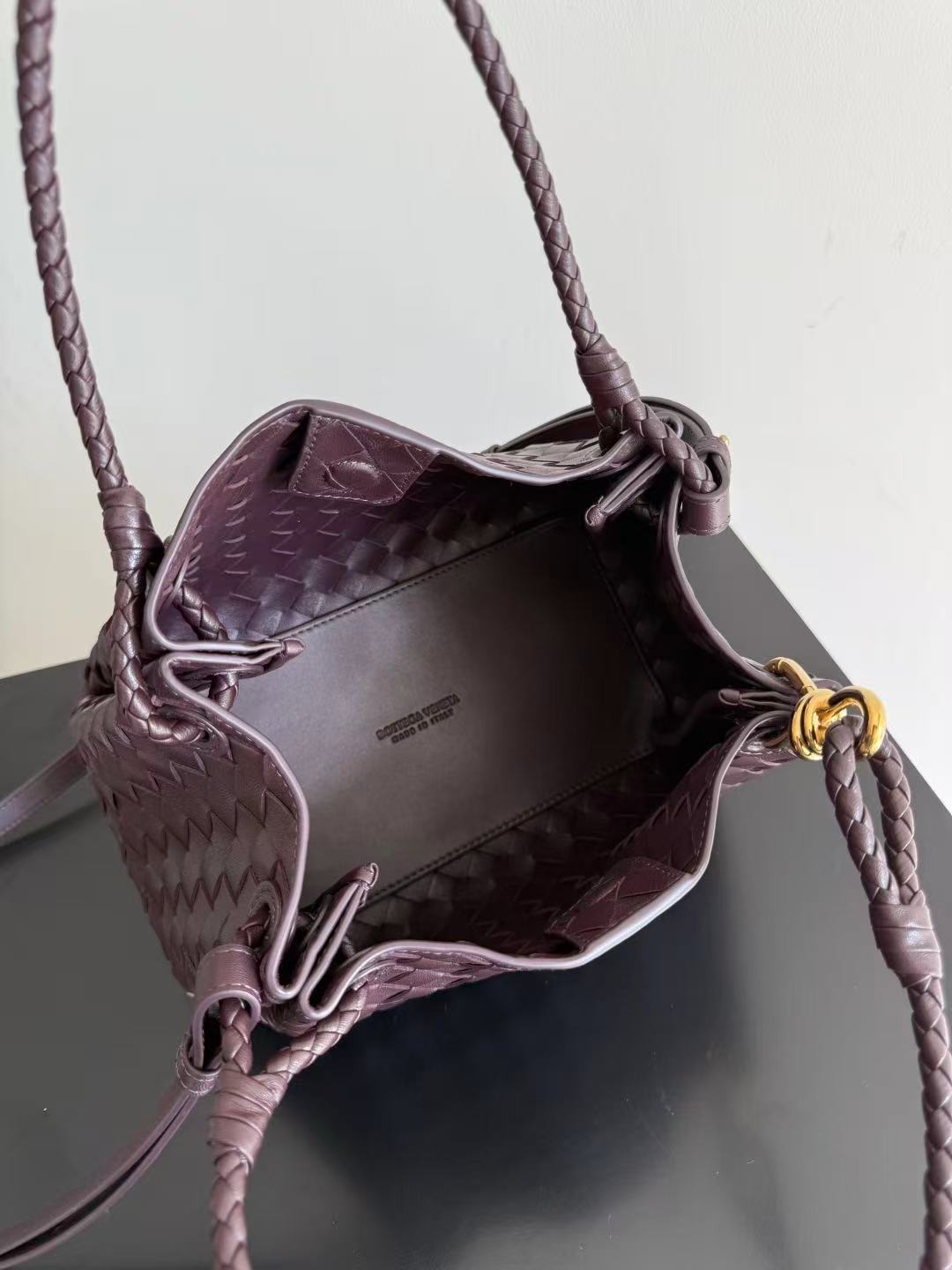 Bottega Veneta Parachute shoulder bag in a dark barolo or burgundy color, featuring the brand's signature intrecciato woven leather design