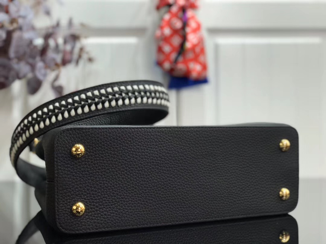 LV Capucines handbag, likely in the BB size, is crafted from black Taurillon leather and features a distinctive jewelry-inspired chain top handle and signature LV initials