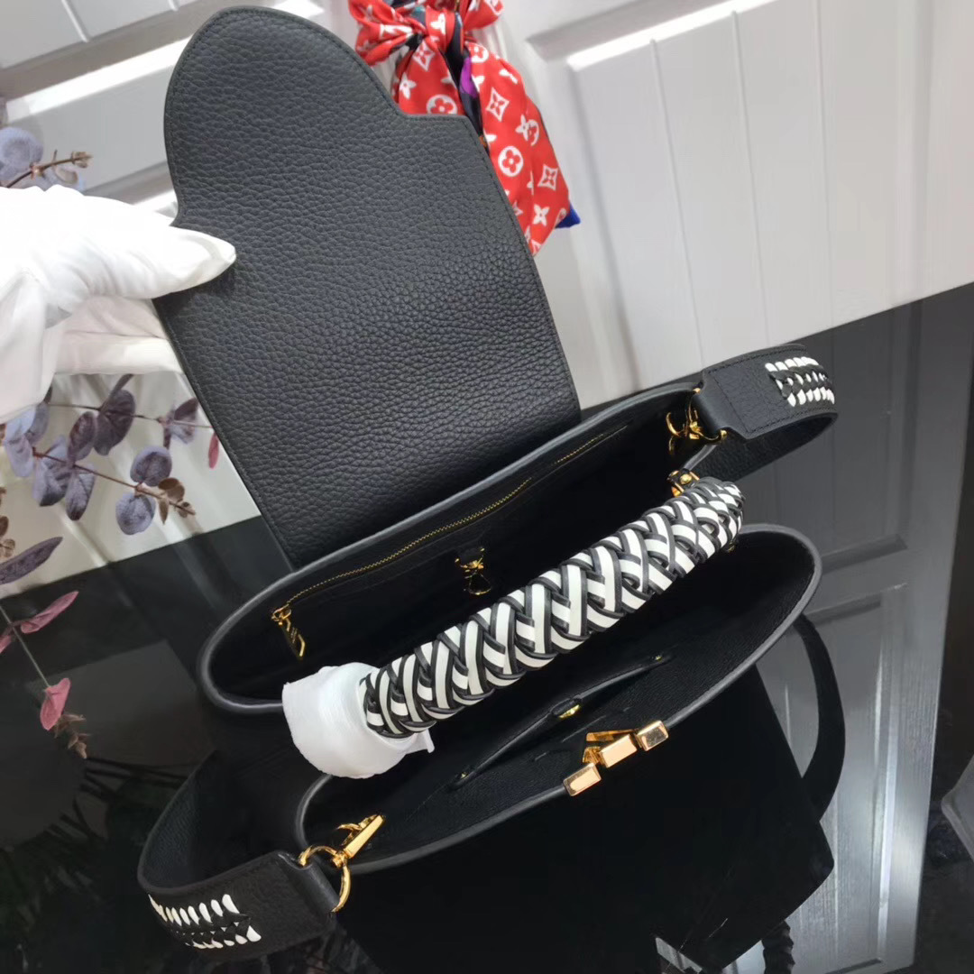 LV Capucines handbag, likely in the BB size, is crafted from black Taurillon leather and features a distinctive jewelry-inspired chain top handle and signature LV initials
