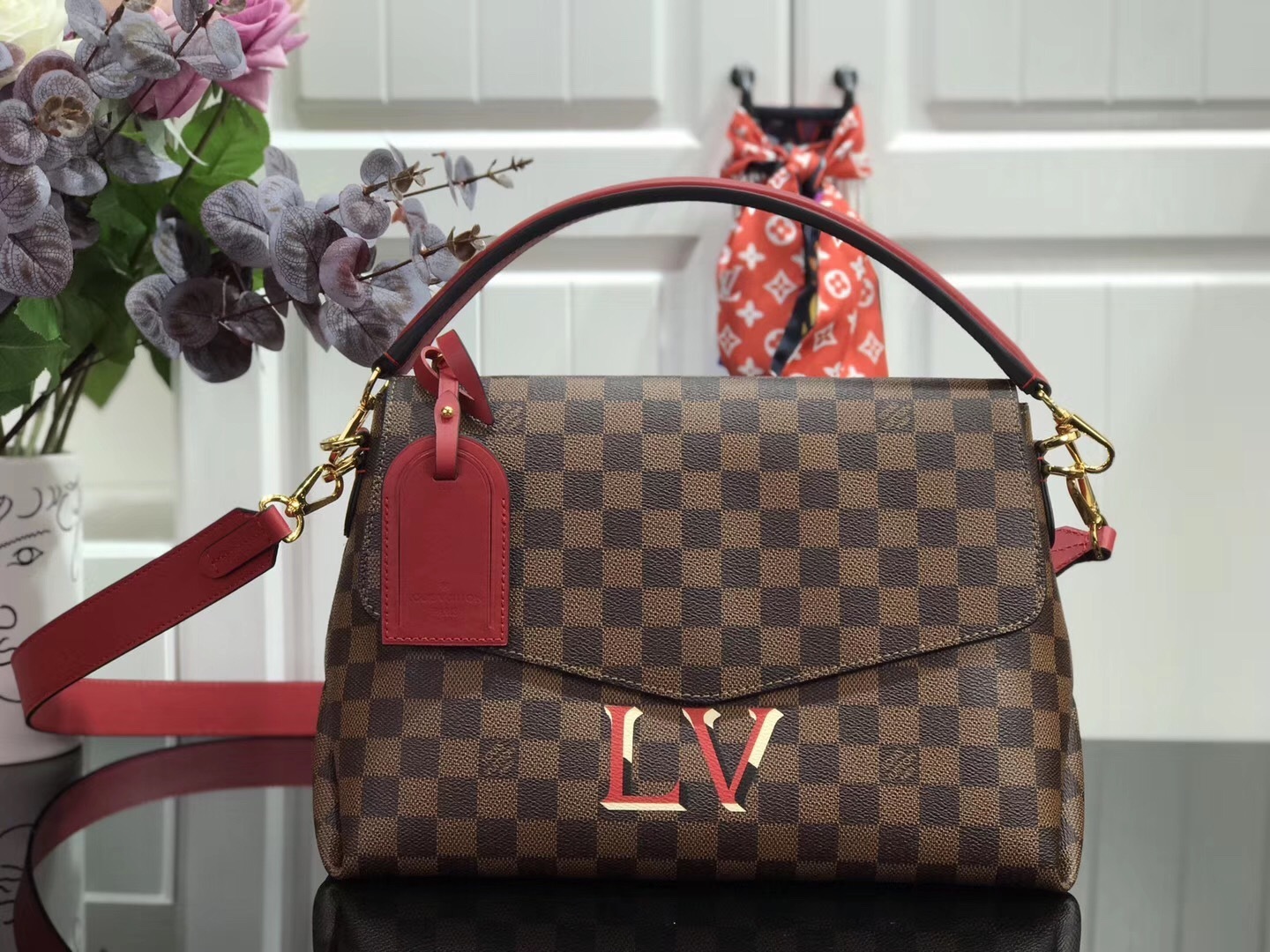 LV Beaubourg MM handbag made from Damier Ebene canvas with red leather details.