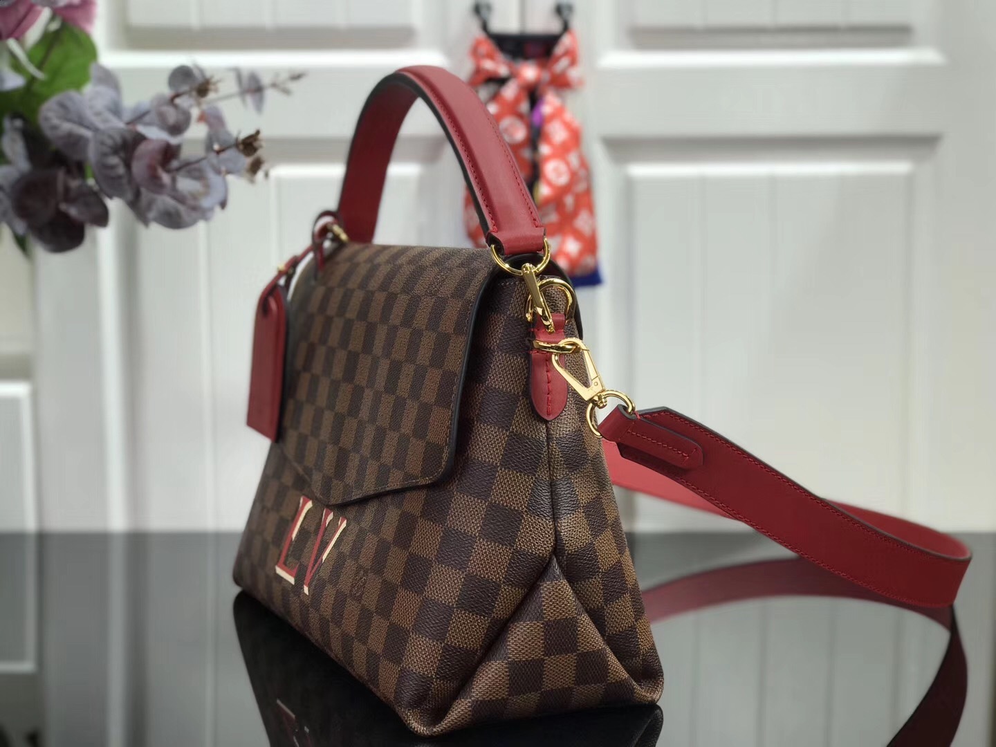 LV Beaubourg MM handbag made from Damier Ebene canvas with red leather details.