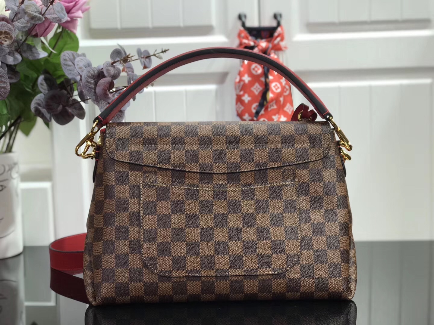 LV Beaubourg MM handbag made from Damier Ebene canvas with red leather details.