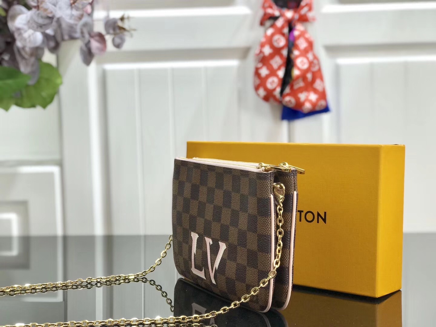 LV Damier Ebene Double Zip Pochette in Pink is a versatile crossbody bag crafted from the iconic checkerboard canvas, featuring distinctive pink leather trim and a prominent LV signature.