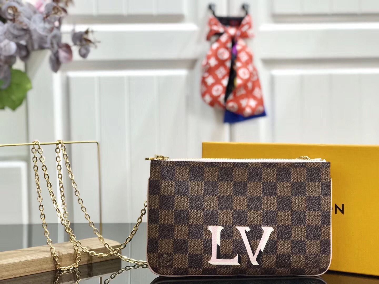 LV Damier Ebene Double Zip Pochette in Pink is a versatile crossbody bag crafted from the iconic checkerboard canvas, featuring distinctive pink leather trim and a prominent LV signature.