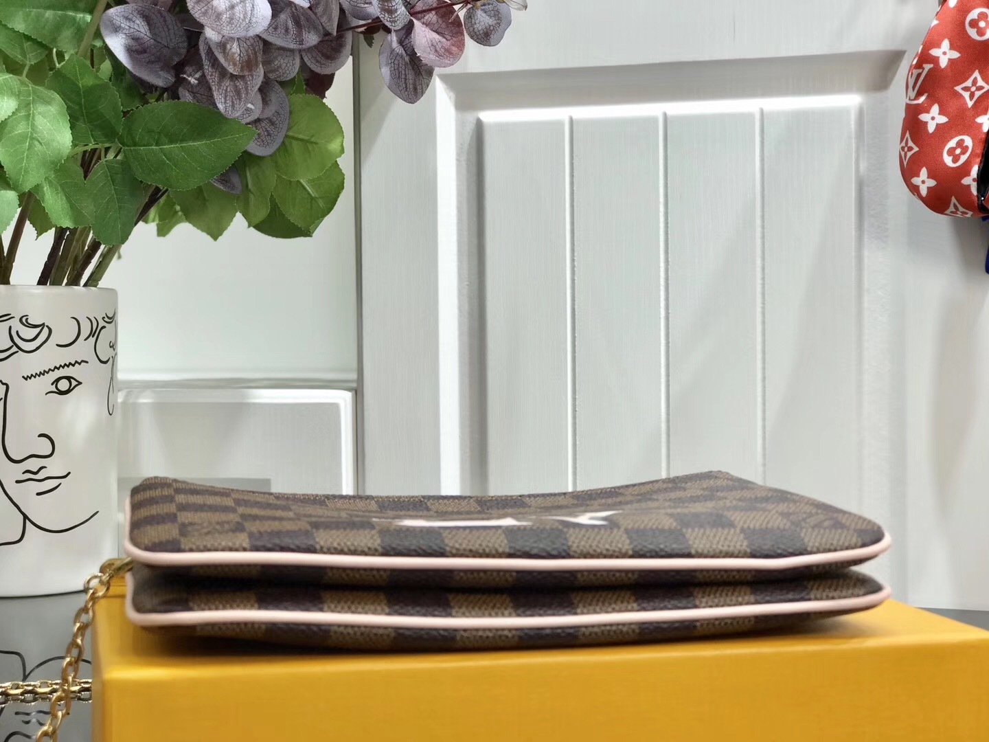 LV Damier Ebene Double Zip Pochette in Pink is a versatile crossbody bag crafted from the iconic checkerboard canvas, featuring distinctive pink leather trim and a prominent LV signature.