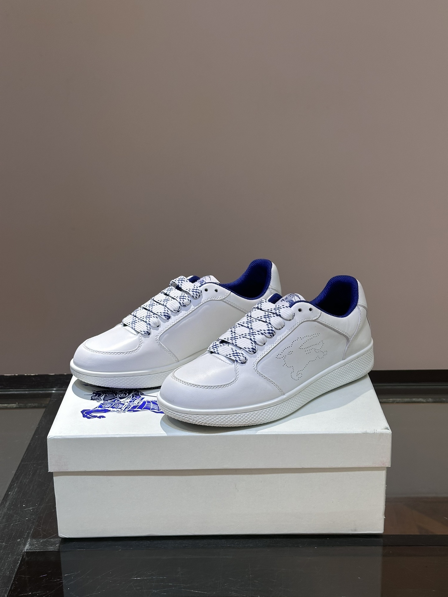 Burberry Stock leather sneakers feature a white calf leather upper, the Equestrian Knight Design perforated on the sides, and a rubber sole.