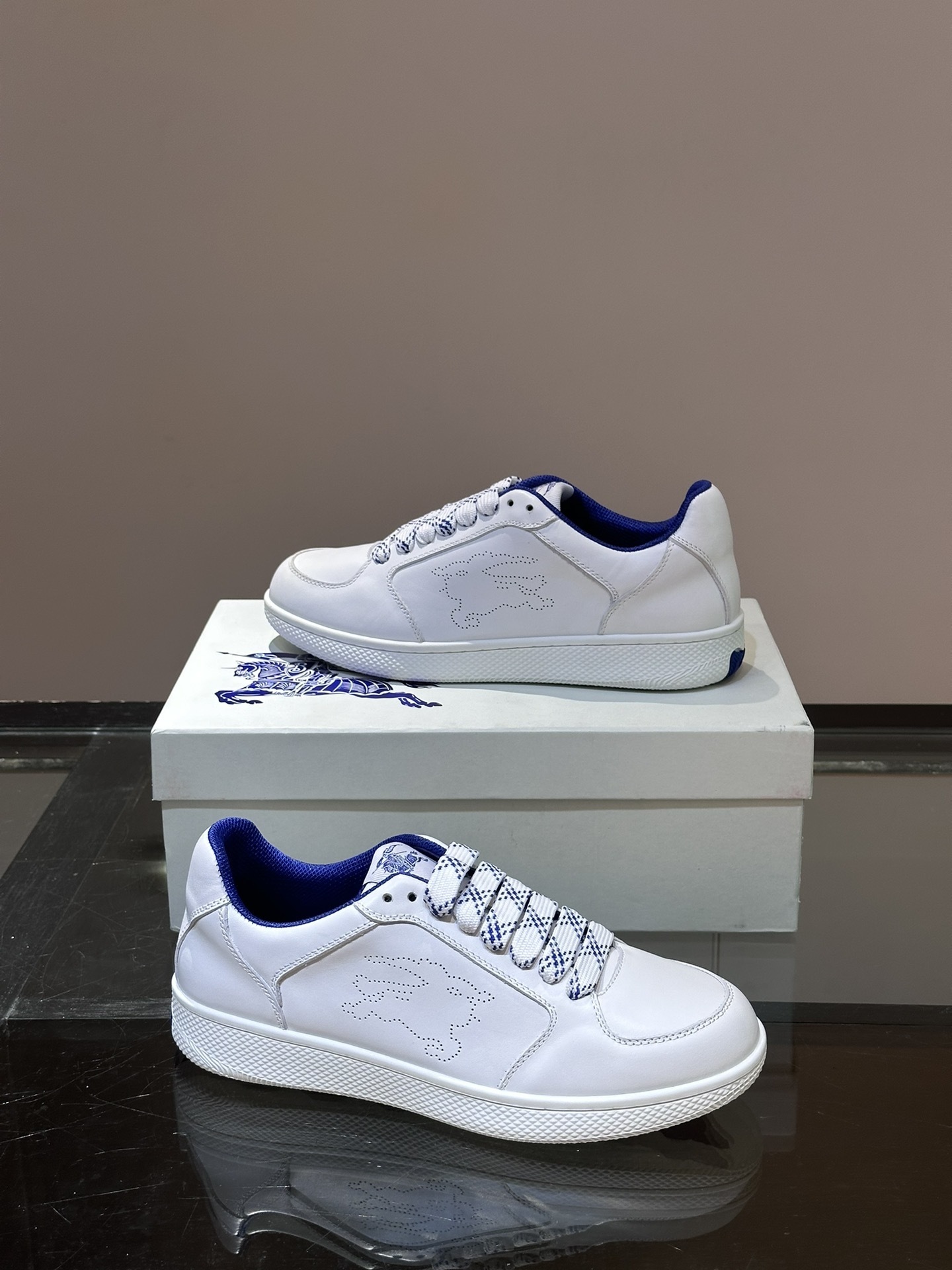 Burberry Stock leather sneakers feature a white calf leather upper, the Equestrian Knight Design perforated on the sides, and a rubber sole.