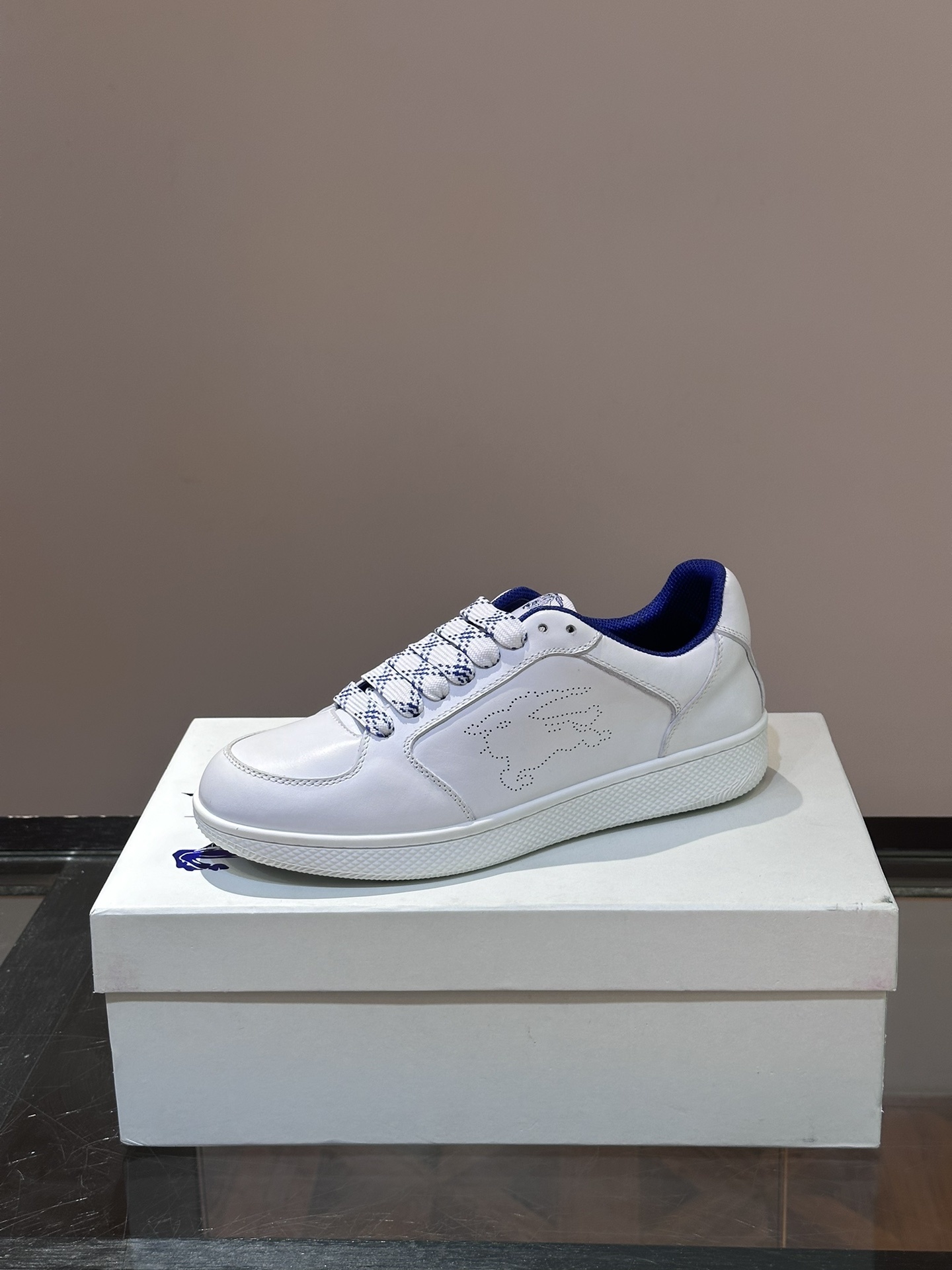 Burberry Stock leather sneakers feature a white calf leather upper, the Equestrian Knight Design perforated on the sides, and a rubber sole.